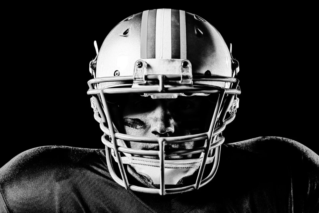 Football player wearing a helmet looking directly into the camera.